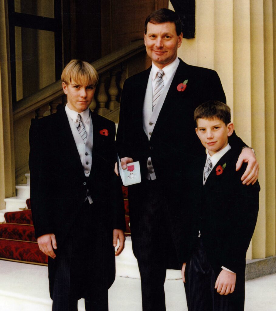 Philip receiving his MBE, with sons Joseph and Chris – both helms at Porthcawl today. Photo by Porthcawl RNLI.
