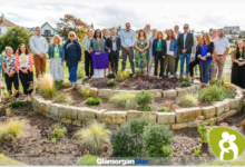 Irfon Rees, centre, with Cllr Elliot Penn, Mayor of the Vale of Glamorgan and Cllr Catherine Iannucci-Williams, the Mayor of Barry, with the team of volunteers and Tŷ Hafan staff behind the creation of this garden. 