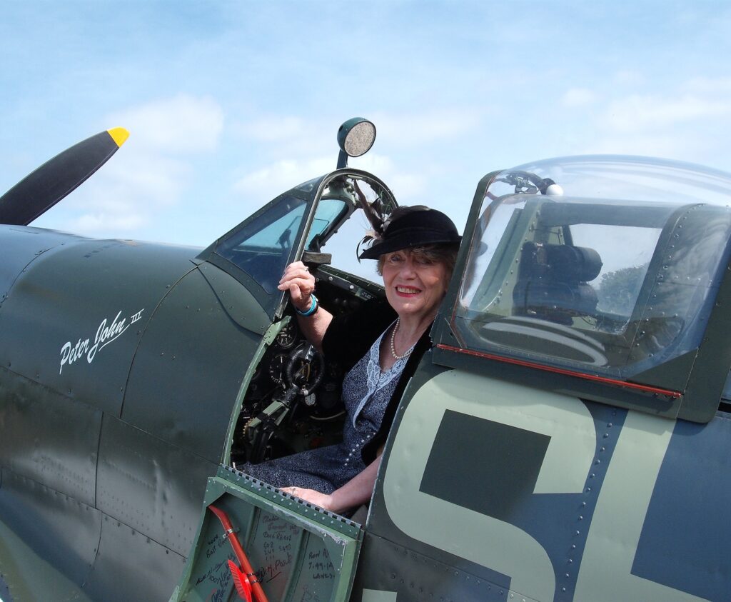 Local historian Rosemary Chaloner in period costume and seated in a Spitfire.