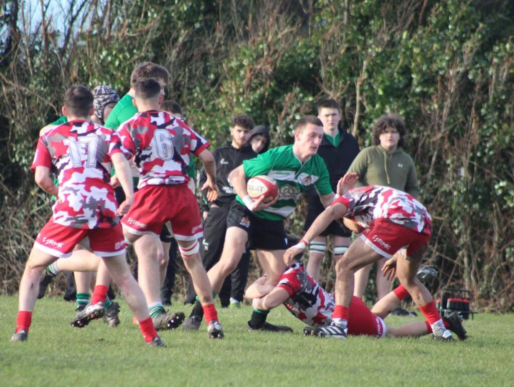 Isaac Thomas is halted by Fairwater defenders. Photo by Judith Dutton.