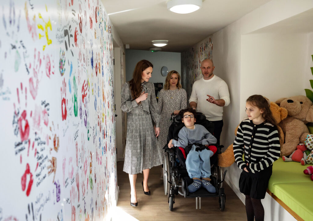Kate having a tour of the hospice standing in front of a wall of handprints including that of King Charles who visited in 2018 when he was the Prince of Wales. Photo: Andrew Parsons / Kensington Palace.