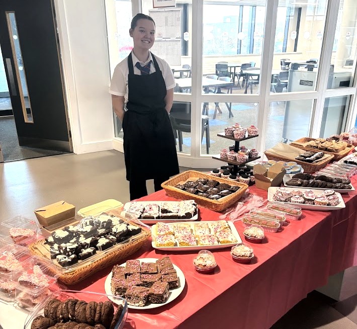 Team member Abi (year-11) prepares the table for a fundraising sale.