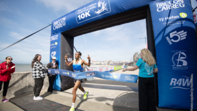 Omar Ahmed crosses the finishing line. | Happy runners on the finishing straight. Photo: Run4Wales.