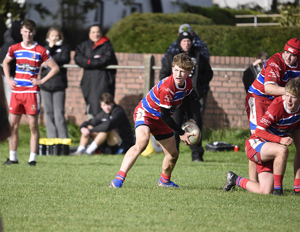 Under-16 action as Finley Keegan sets his backs in motion.