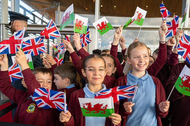 Waving the flags with pride, primary schools were invited to greet The King and Queen at the Senedd. Photo: Welsh Parliament.